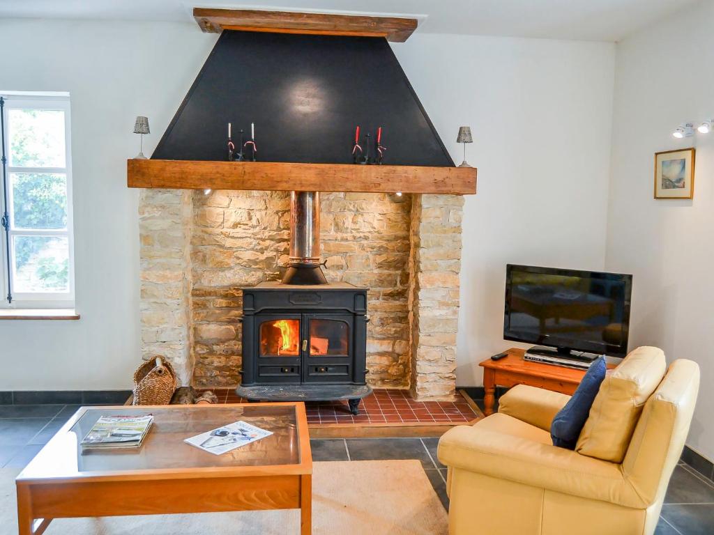 a living room with a fireplace and a tv at Holiday Home L'Ancienne Scierie by Interhome in Saint-Martin-sur-Armançon