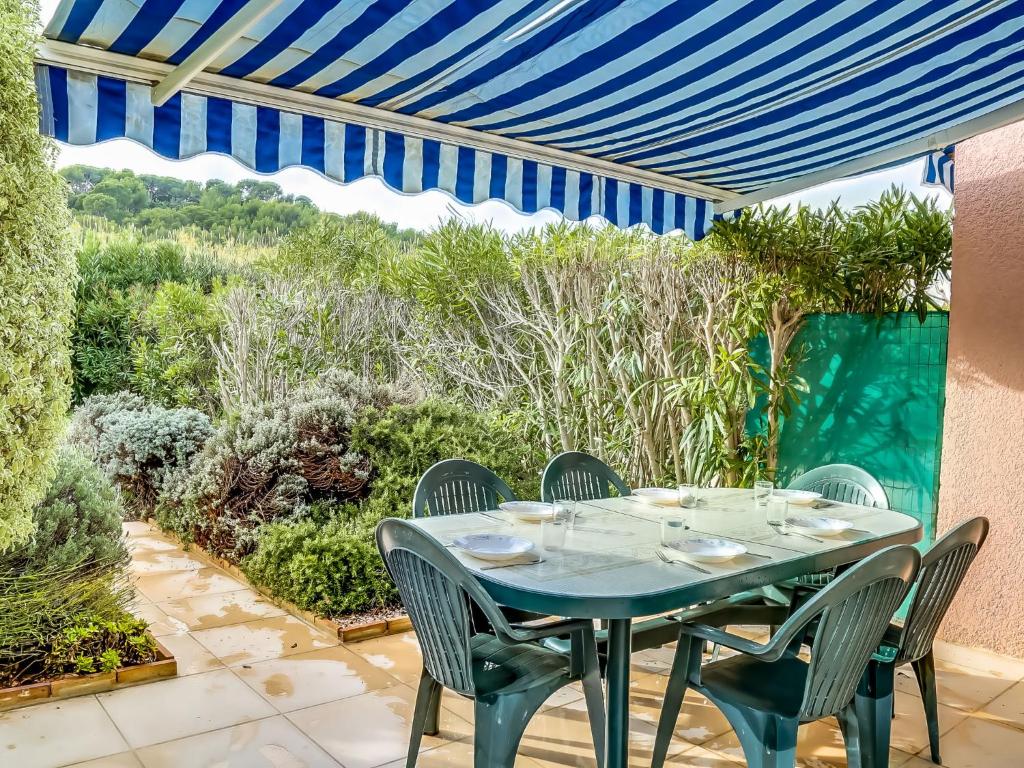ル・ラヴァンドゥーにあるHoliday Home Le Domaine d'Azur-2 by Interhomeの青いテーブルと椅子が備わるパティオ