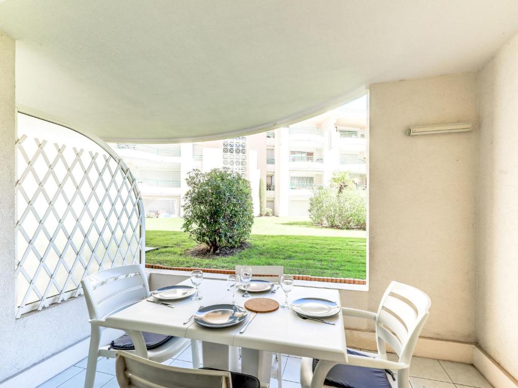 フレジュスにあるApartment Le Cesarée-4の白いテーブルと椅子、窓のあるバルコニー