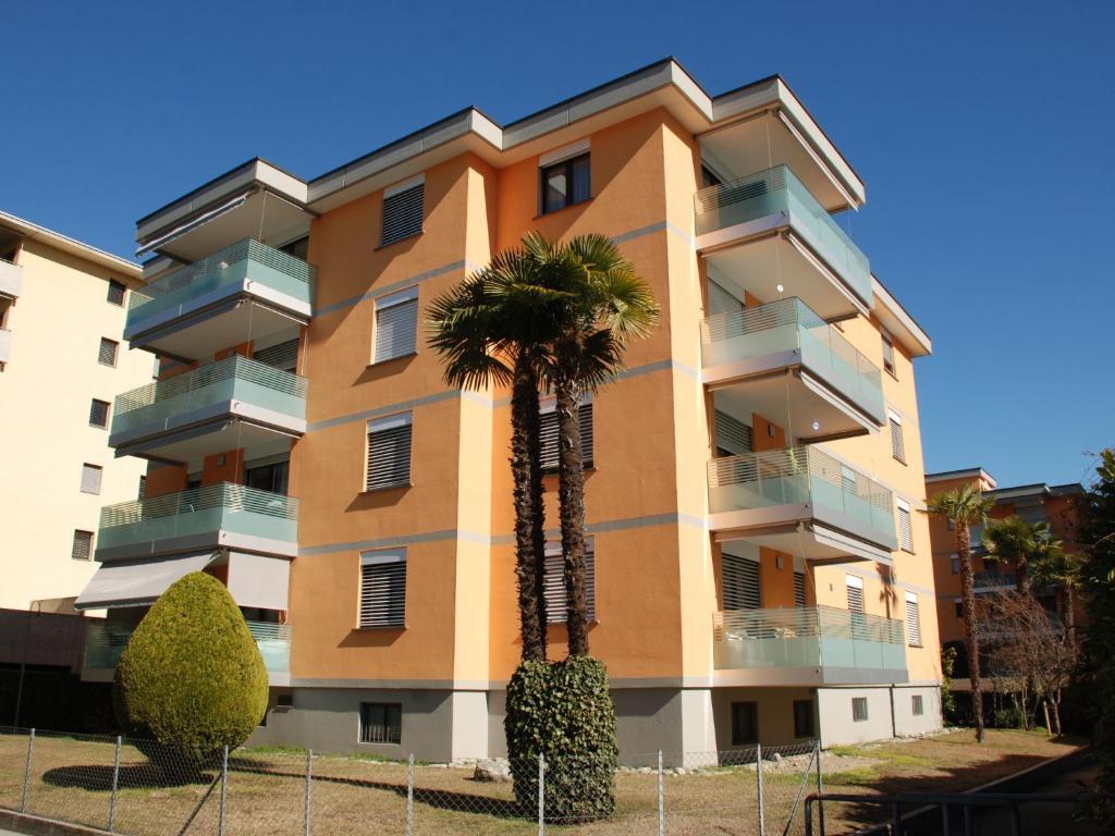 a building with a palm tree in front of it at Apartment Saleggi Apt- 20 by Interhome in Locarno