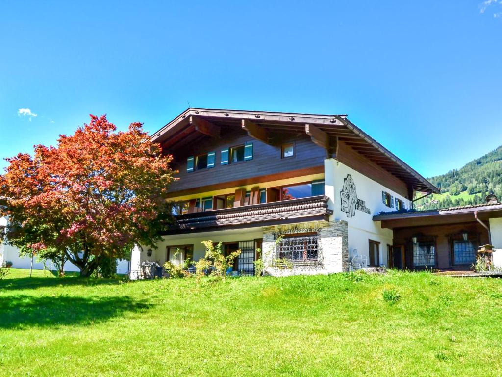 ein Haus auf einem Hügel mit einem Baum davor in der Unterkunft Apartment Apartmenthaus Dreier-1 by Interhome in Neukirchen am Großvenediger