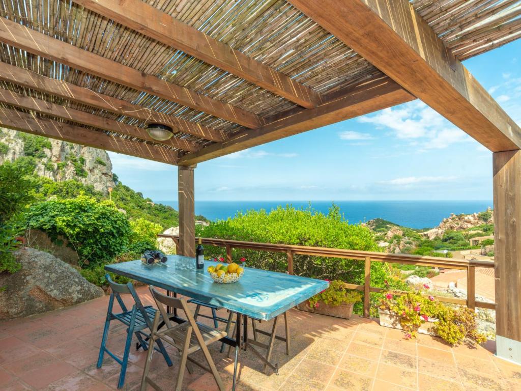 a table on a patio with the ocean in the background at Holiday Home Il Muto by Interhome in Li Valcaggi