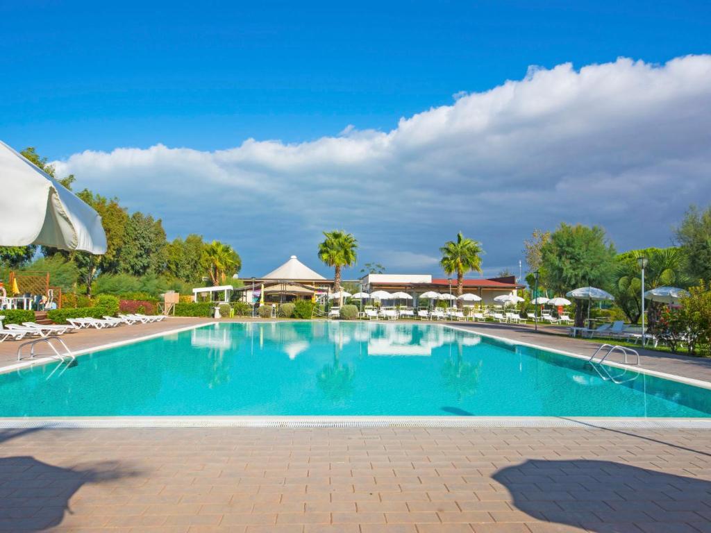 basen w ośrodku z krzesłami i drzewami w obiekcie Holiday Home Cecina Mare-15 by Interhome w mieście Marina di Cecina