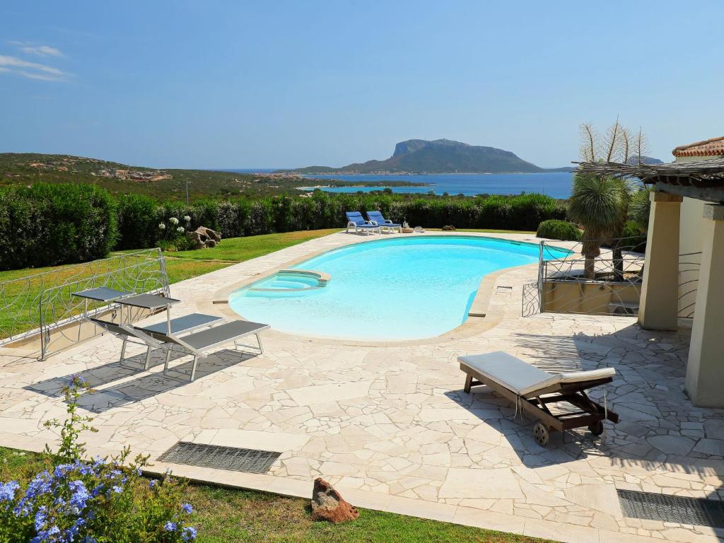 een zwembad met 2 ligstoelen en de oceaan bij Holiday Home Iris by Interhome in Marinella