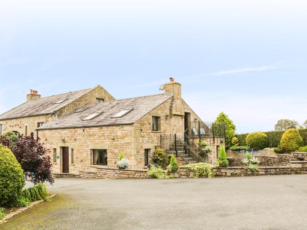 an old stone house with a driveway at Hazelwood Cottage in Ingleton
