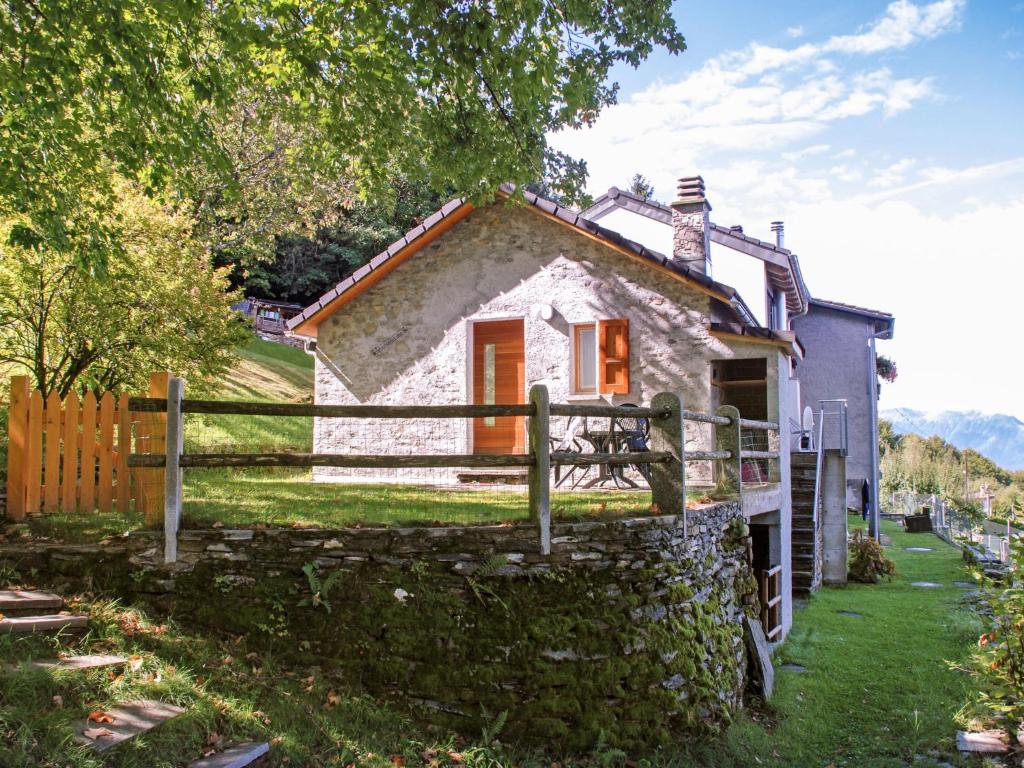 una pequeña casa de piedra con una valla alrededor en Holiday Home La Cassìna by Interhome en Bellinzona