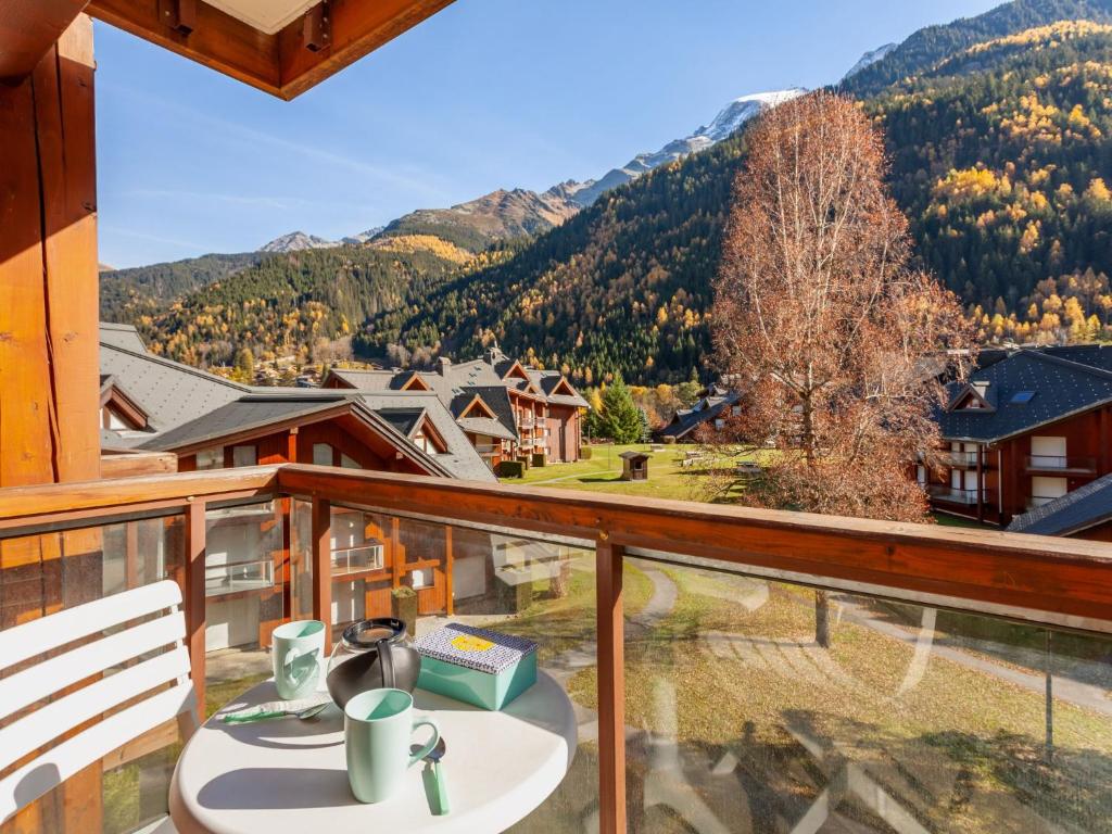 a balcony with a table and a view of the mountains at Studio La Borgia A- B- C-11 by Interhome in Les Contamines-Montjoie
