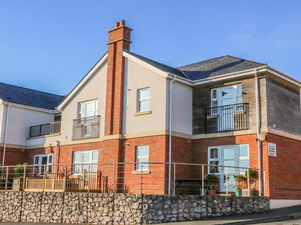 a large brick house with a stone wall at Beach View in Benllech