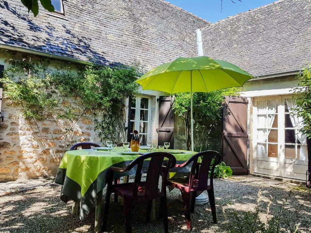 une table avec un parasol vert devant une maison dans l'établissement Holiday Home Vielcroze by Interhome, à Turenne