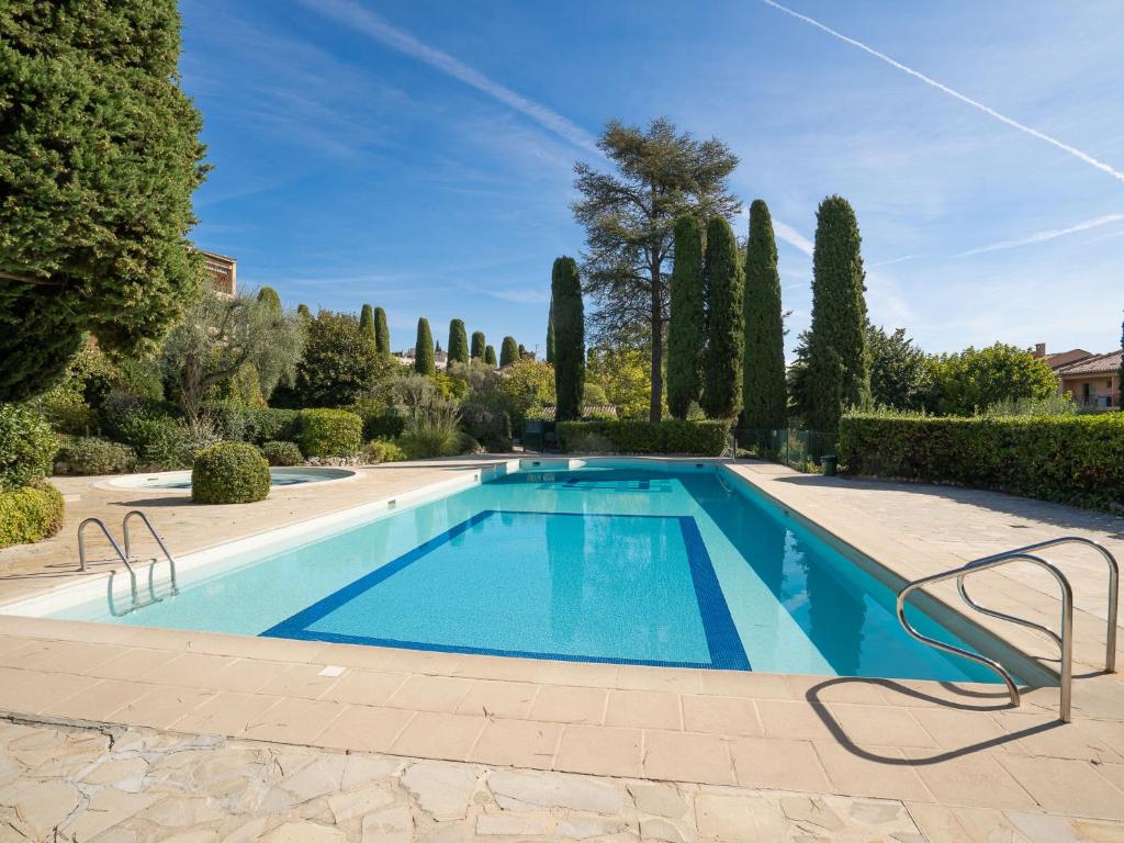 a swimming pool in a garden with trees and bushes at Apartment L'Orée de Vence by Interhome in Vence