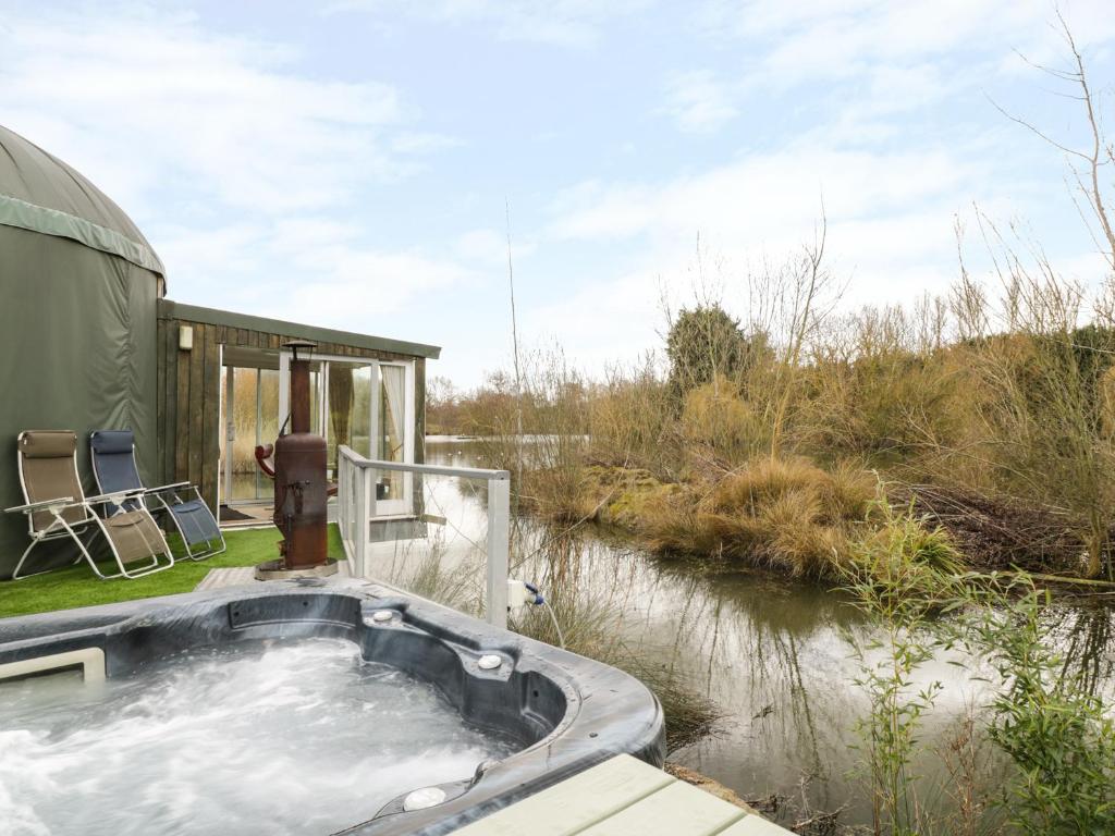 a bath tub in the middle of a river at Secret Island Yurt in Beckford
