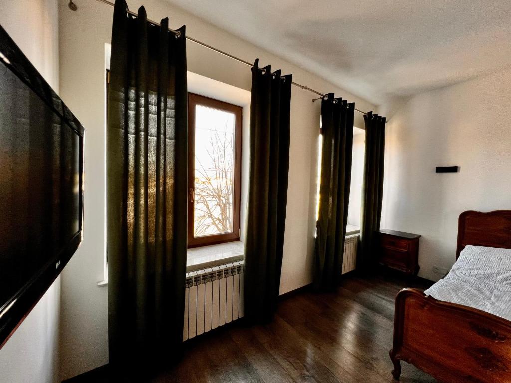 1 dormitorio con cortinas negras y ventana en Apartament na Maja -2-, en Skierniewice