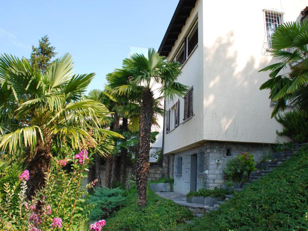 a building with palm trees in front of it at Holiday Home Nido di Rondine-1 by Interhome in Viganello