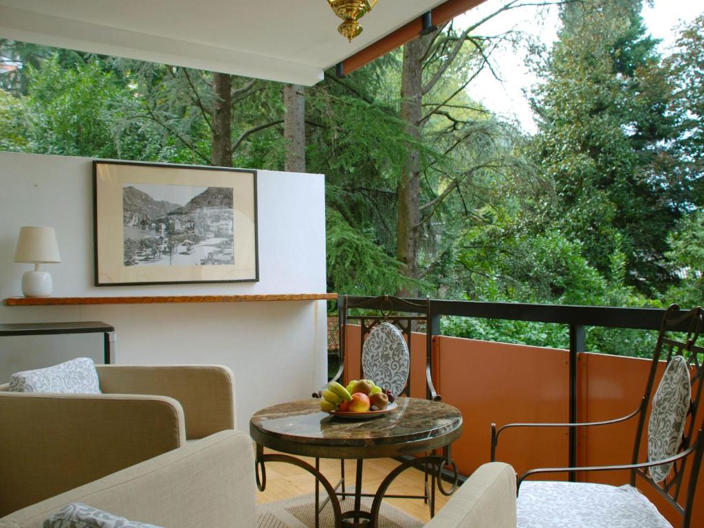 Un balcón con una mesa con un bol de fruta. en Apartment Lago di Lugano-7 by Interhome, en Bissone
