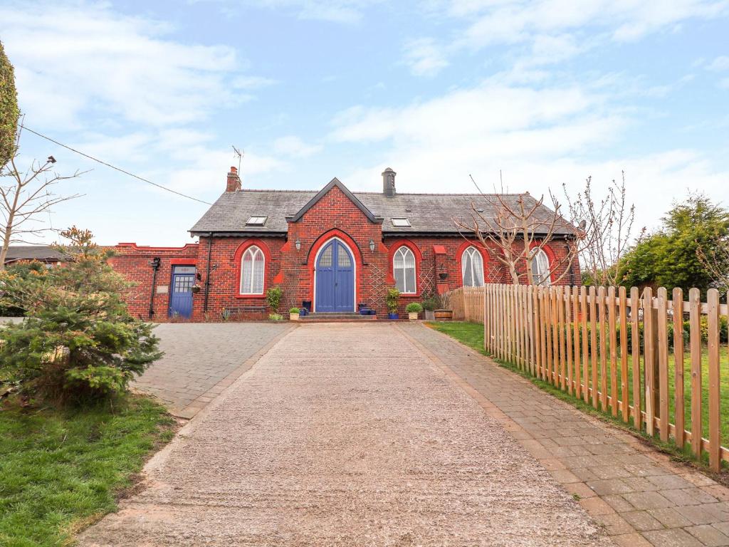 a red brick house with a blue door at Bethania Chapel Annex in Bagillt