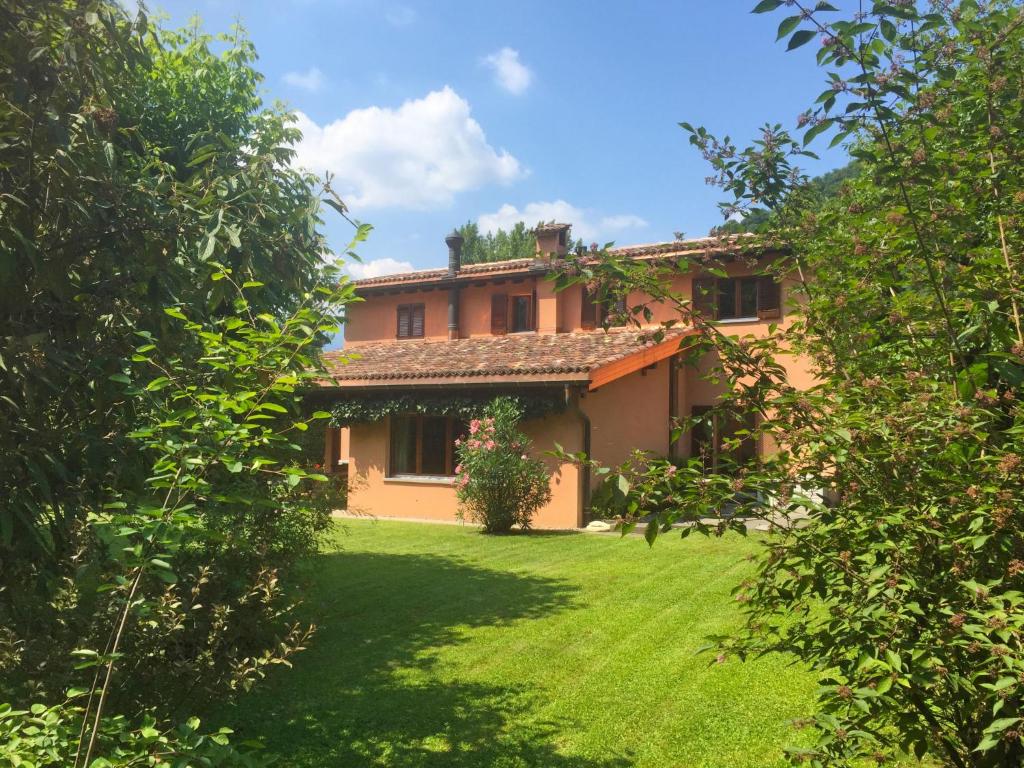 dom z zielonym ogródkiem przed nim w obiekcie Holiday Home Riva by Interhome w mieście Figino