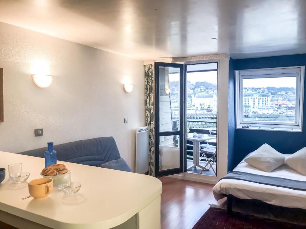 a room with a bed and a table and a couch at Studio Les Marinas-10 by Interhome in Deauville