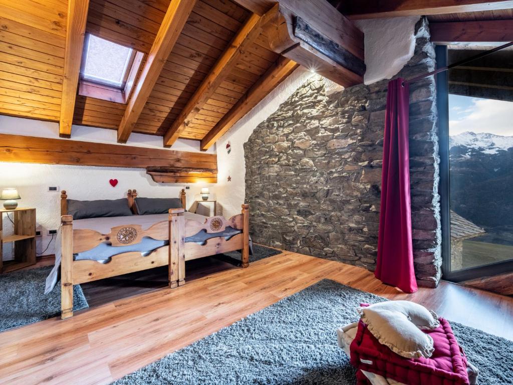 sypialnia z łóżkiem i kamienną ścianą w obiekcie Apartment Maison Chez Nous by Interhome w mieście Sarre