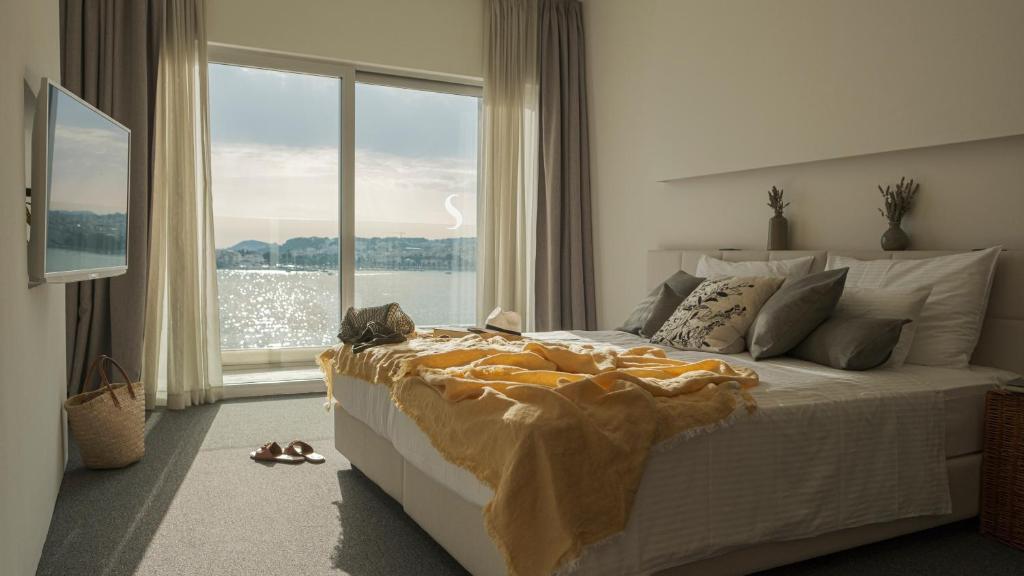 1 dormitorio con 1 cama grande y ventana grande en Hotel Split, en Podstrana