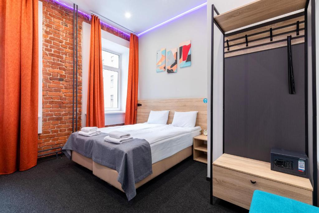 a bedroom with a bed and a brick wall at IZZZI at Vladimirskaya in Saint Petersburg