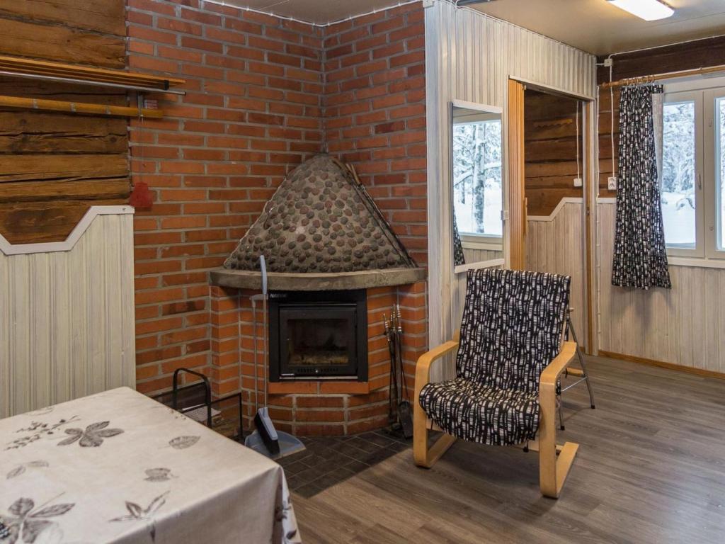 ein Backsteinzimmer mit einem Stuhl und einem Kamin in der Unterkunft Holiday Home Pääsky by Interhome in Urimolahti