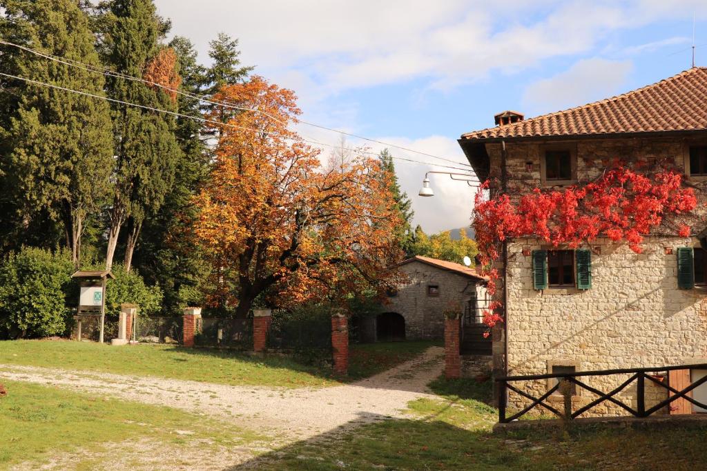 una casa con flores rojas a un lado. en Agriturismo Villaggio Eden, en Pieve Santo Stefano