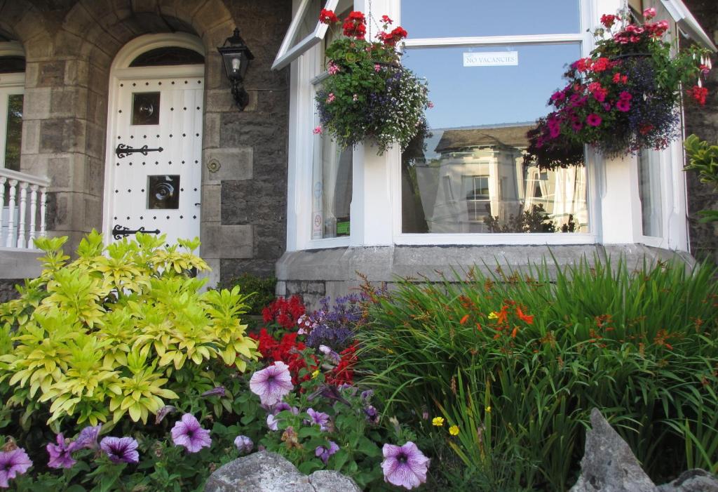 ein Haus mit Blumen vor einem Fenster in der Unterkunft Hillside Bed & Breakfast in Kendal