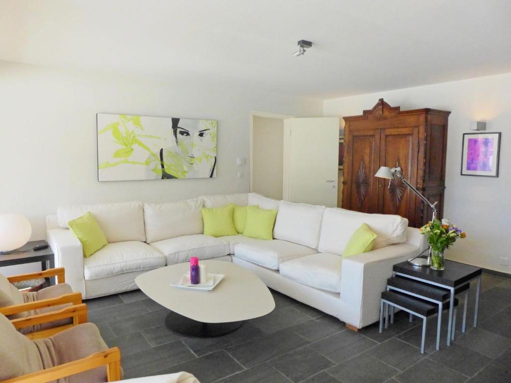 un soggiorno con divano bianco e tavolo di Apartment Chesa Sur Puoz 7 by Interhome a Samedan