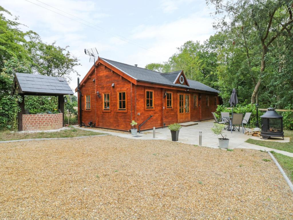 ein Holzhaus mit einem großen Hof davor in der Unterkunft Acorn Lodge in Saxmundham
