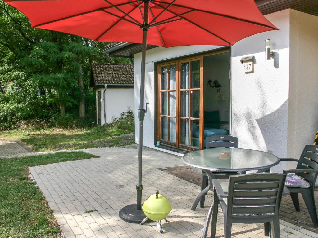 - une table avec un parasol rouge sur la terrasse dans l'établissement Holiday Home Elke's Traum by Interhome, à Frankenau