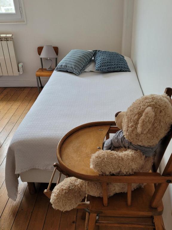 a teddy bear sitting in a table next to a bed at LA P&#39;TITE YPORTAISE in Yport