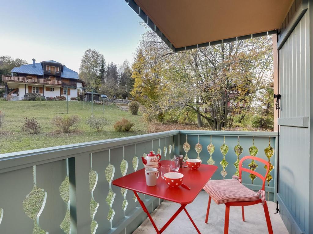 una mesa roja y 2 sillas en el balcón en Apartment Parc du Mont Joly-2 by Interhome, en Saint-Gervais-les-Bains