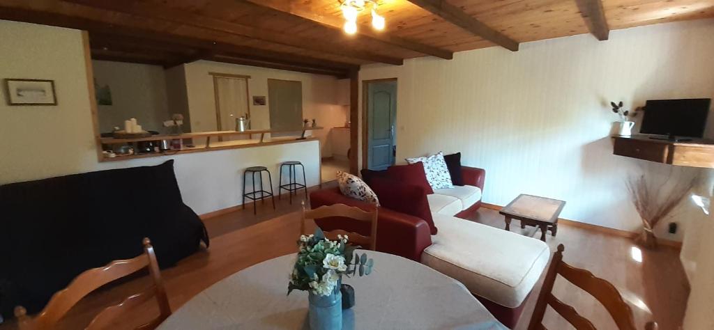 uma sala de estar com sofás e uma mesa e uma cozinha em L' appartement du Camping Hautoreille em Bannes