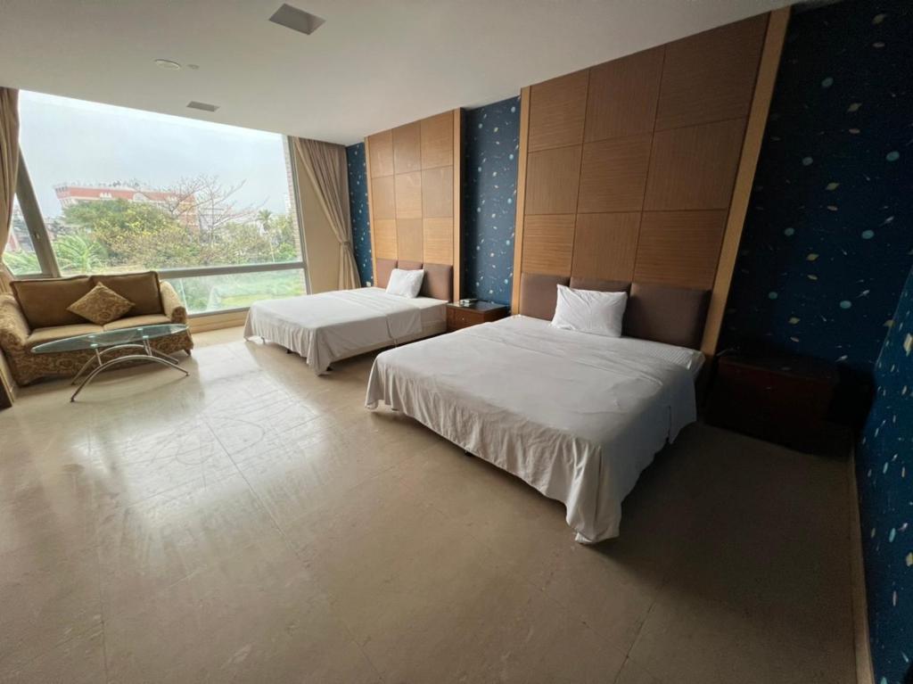 um quarto de hotel com duas camas e uma janela em Charming Motel em Hualien