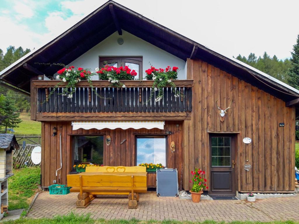 a wooden house with a balcony and a bench at Holiday Home Panoramablick by Interhome in Piesau