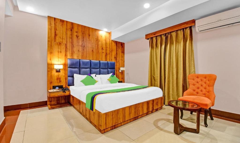 a bedroom with a bed and a chair at Treebo Trend The Pearl Bliss in Patna