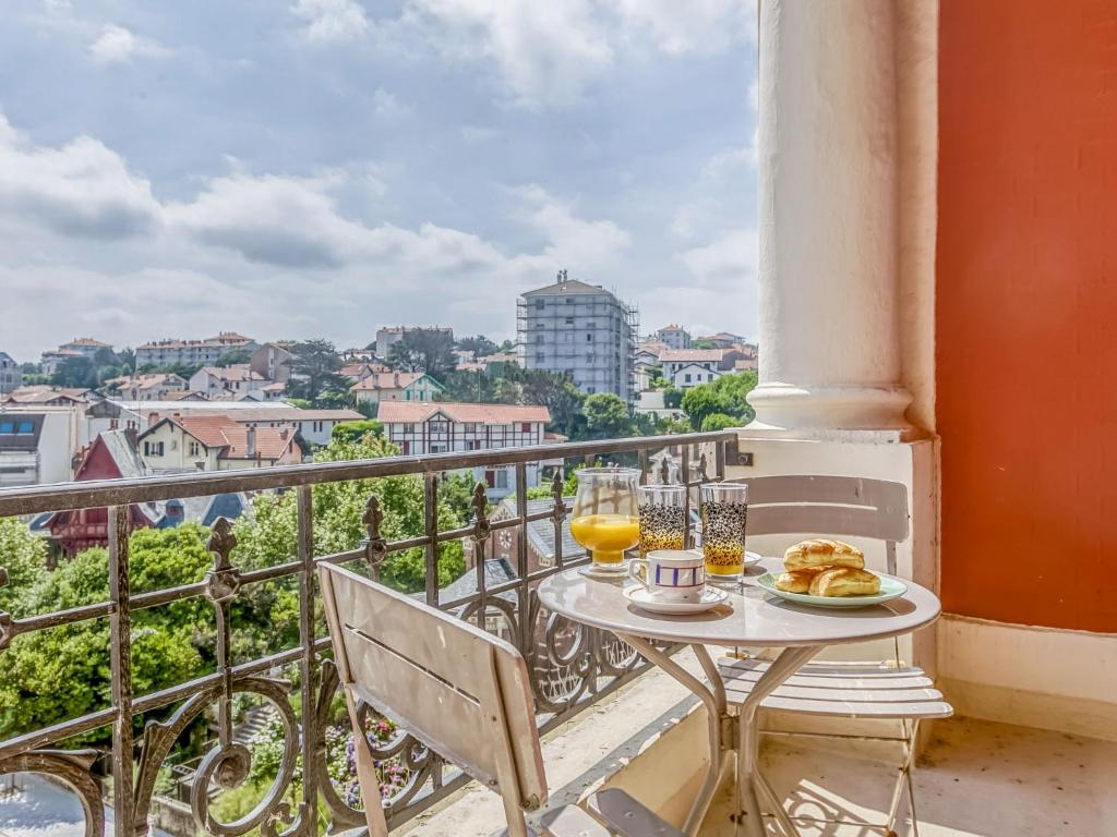 une table avec une assiette de nourriture sur un balcon dans l'établissement Apartment Carlton-2 by Interhome, à Biarritz