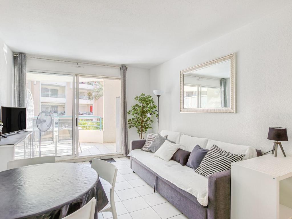 a living room with a couch and a table at Apartment Le Cesarée-5 by Interhome in Fréjus