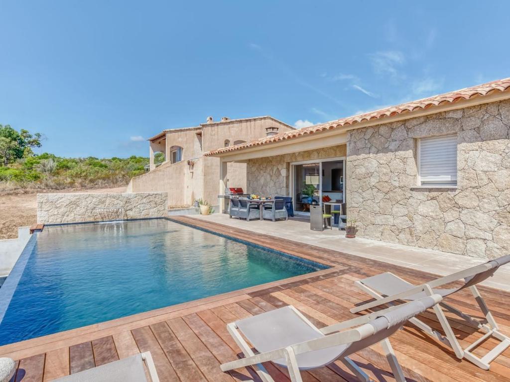 une villa avec une piscine et deux chaises dans l'établissement Holiday Home Villa Belios by Interhome, à Porto-Vecchio