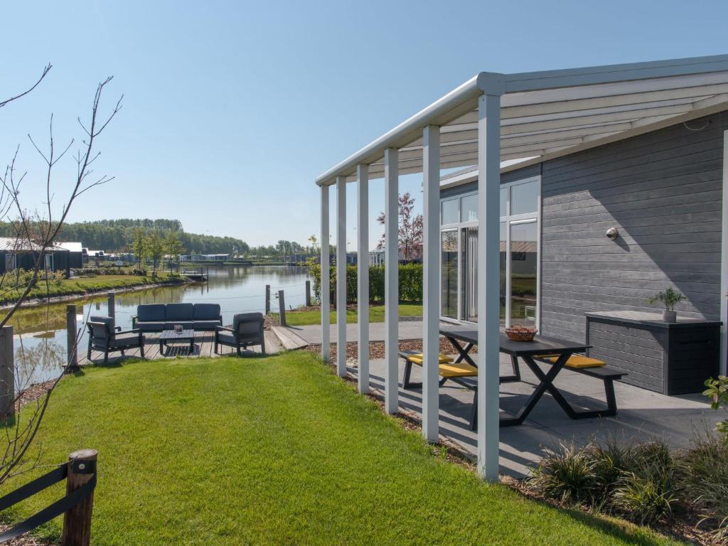 a house with a patio with a view of a river at Holiday Home Ruisweg 38 by Interhome in Wemeldinge