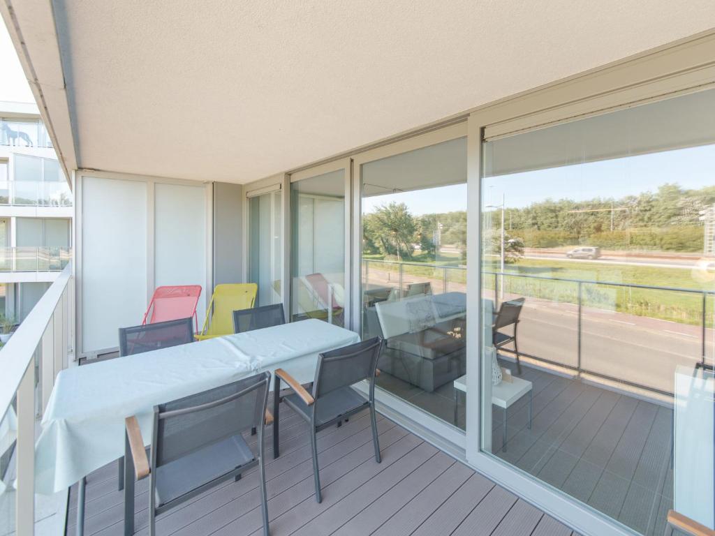 Zimmer mit einem Tisch und Stühlen auf einem Balkon in der Unterkunft Apartment Residentie Odyssea I by Interhome in Bredene
