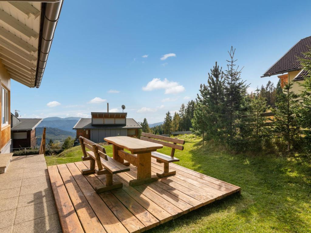 una mesa de picnic y un banco en una terraza de madera en Apartment Pistenblick-2 by Interhome, en Hochrindl