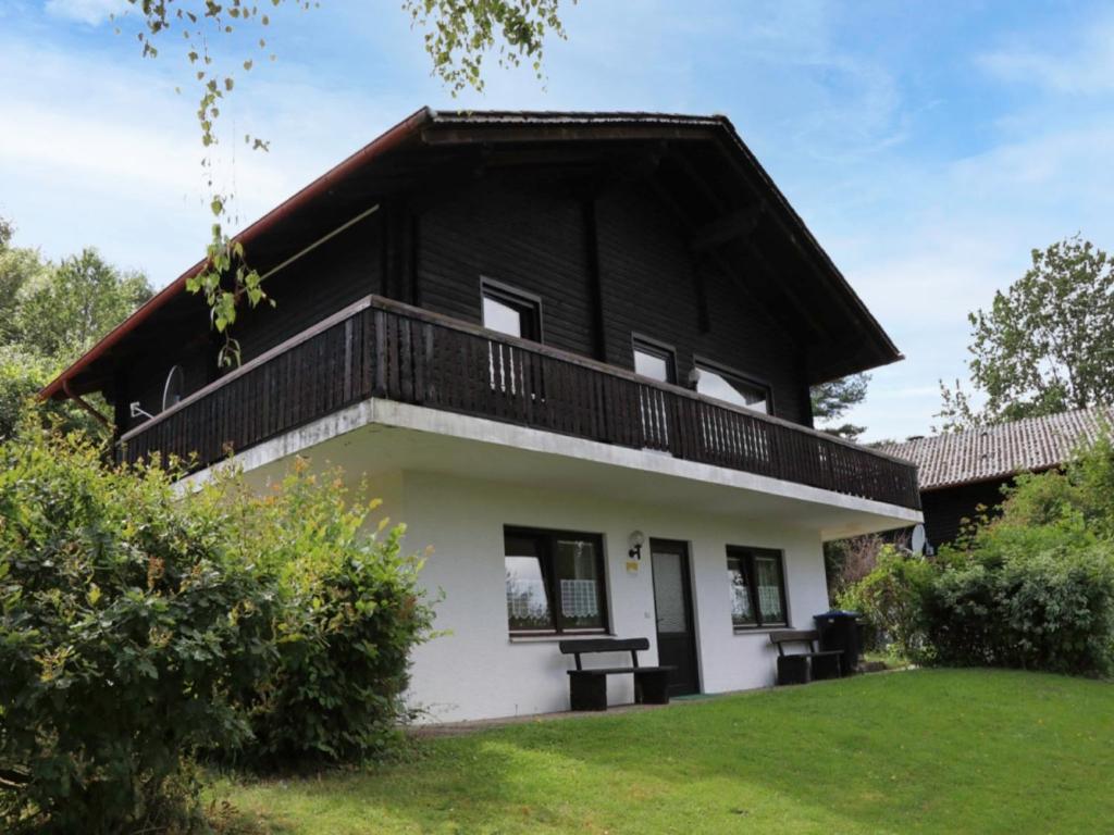 a black and white house with a balcony at Holiday Home Ferienpark Himmelberg-5 by Interhome in Thalfang