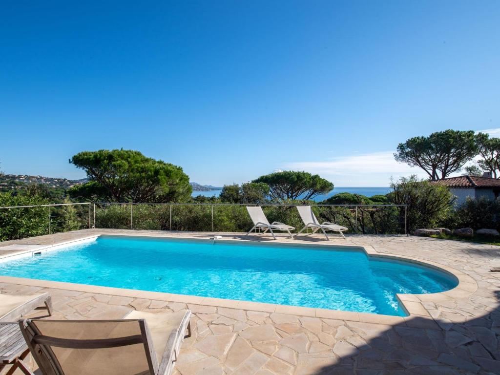 une piscine avec 2 chaises longues et une piscine dans l'établissement Holiday Home Villa Cap Maxime by Interhome, à Sainte-Maxime