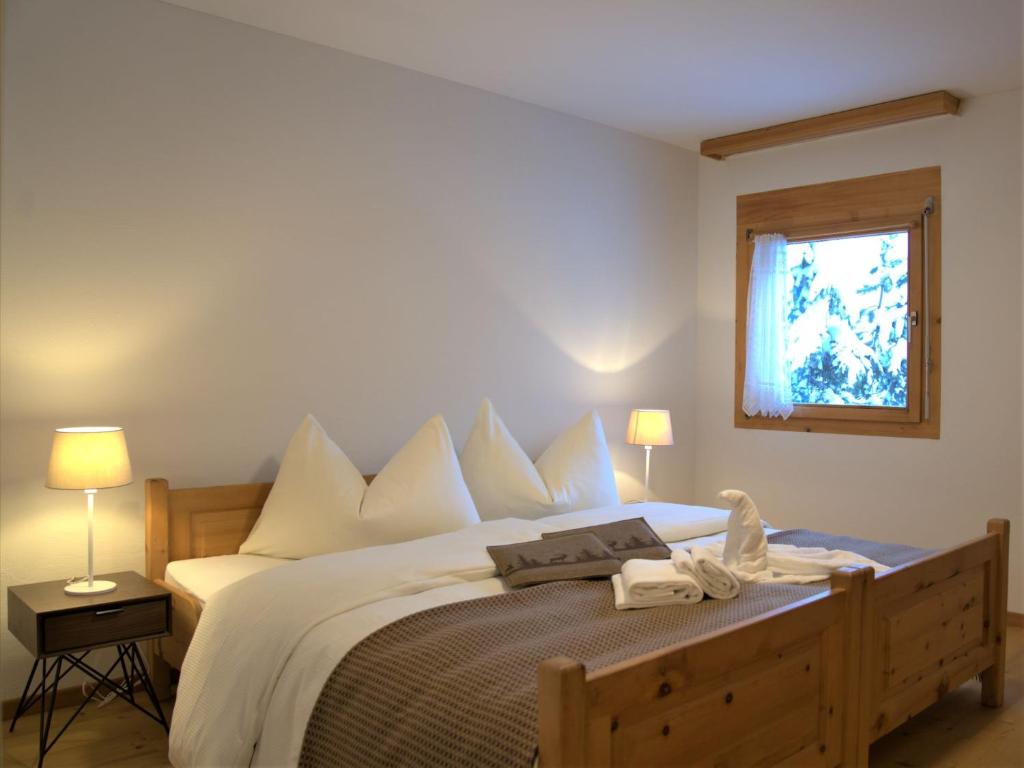 um quarto com uma cama com lençóis brancos e uma janela em Apartment Chesa Ginellas by Interhome em Sils Maria