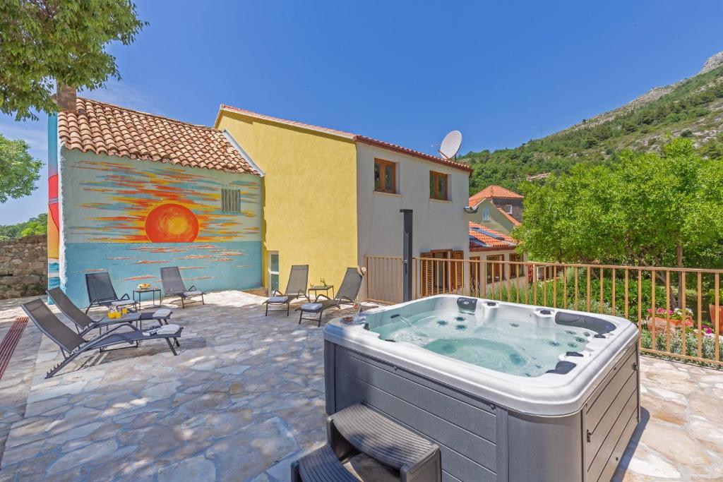bañera de hidromasaje en un patio con sillas y un edificio en Holiday Home Ana's Paradise, en Mlini