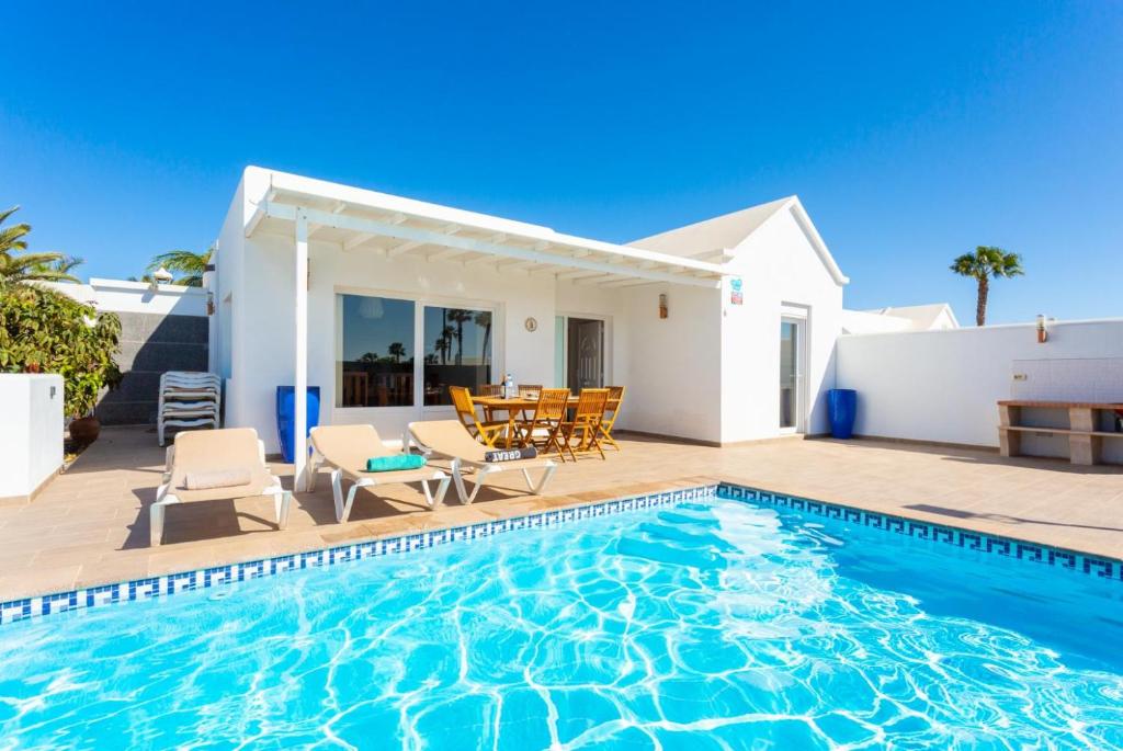 a villa with a swimming pool in front of a house at Villa Diego in Mácher