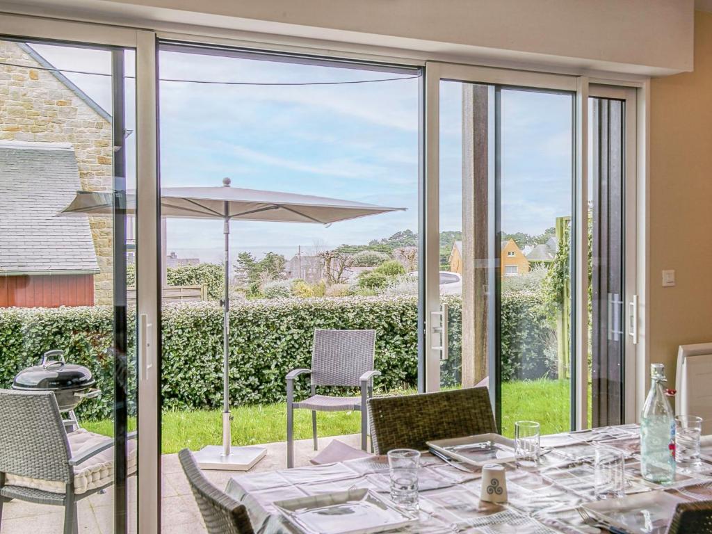 une salle à manger avec une table et une grande baie vitrée dans l'établissement Apartment Les Hauts de Port Mer by Interhome, à Cancale