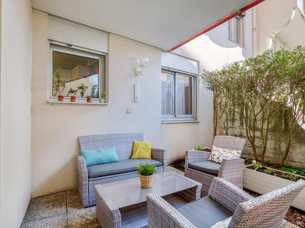 d'une terrasse avec des chaises en osier et une table. dans l'établissement Apartment Bibi Beaurivage by Interhome, à Biarritz