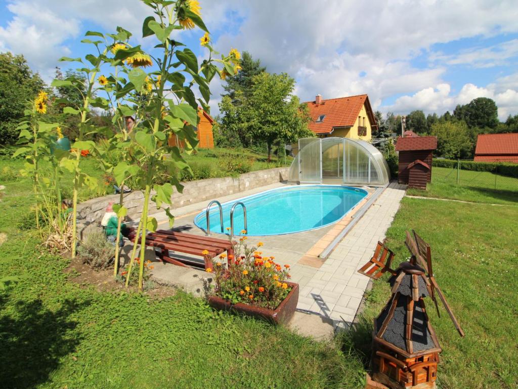 a swimming pool in a yard with a garden with a tree at Holiday Home Zásada by Interhome in Zásada